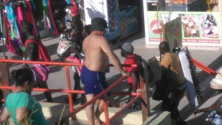 Comerciantes senegaleses corren hacia la costanera luego del operativo de control de venta clandestina en la playa.