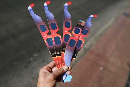 Una personas sostiene lentes especiales para mirar el eclipse solar en la plaza pública de la región de Coquimbo, Chile, 30 de junio de 2019. REUTERS/Pablo Sanhueza