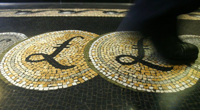 FOTO DE ARCHIVO: Un empleado es visto caminando sobre un mosaico de símbolos en libras esterlinas en el piso del hall del Banco de Inglaterra, en Londres, el 25 de marzo de 2008. REUTERS/Luke