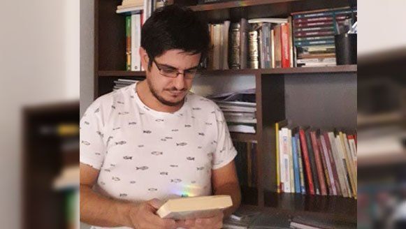 Juan Pablo Dobratinich en su casa, repasando su biblioteca.