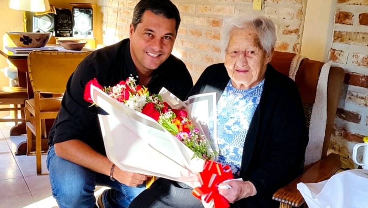 Elintendente Carlos Koopmann junto a Lois Trannack, de 101 años,historia viva de Zapala.Las flores delpresente y la memoria de una ciudad que cumple 113 años.