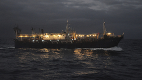 Buque jigger chino iluminado capturando calamar en alta mar durante la noche. | LM Neuquen Buque jigger chino iluminado capturando calamar en alta mar durante la noche.