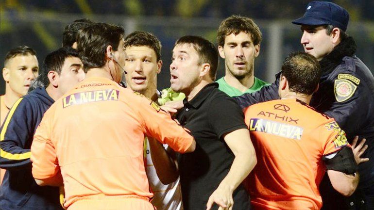 Una triste postal de la final. Todo Central le protesta a Ceballos por el penal que cobró afuera del área.