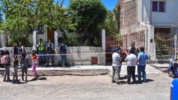 A la izquierda, familiares de la mujer alrededor de la vivienda en Villa Ceferino. A la derecha, los investigadores. &nbsp;