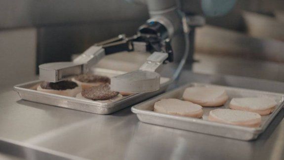 Pone las hamburguesas a cocinar y luego las coloca en los panes.