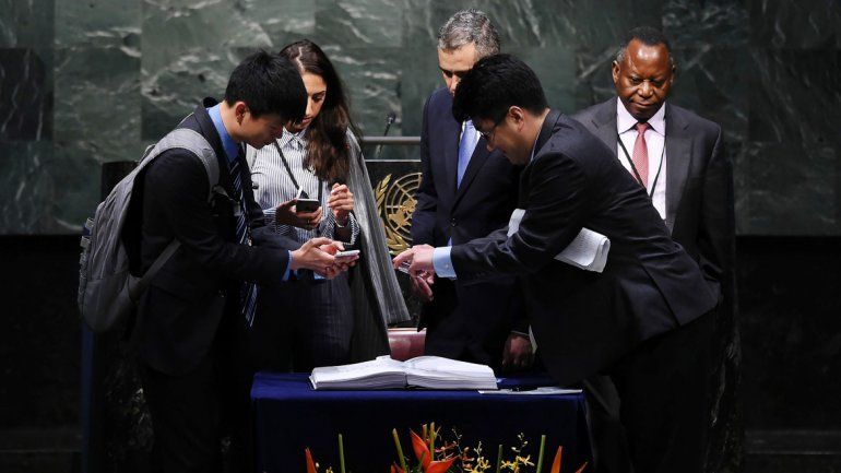 Diplomáticos sacan fotos al texto del acuerdo suscripto ayer.