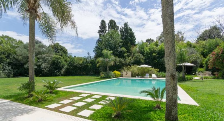 La gran pileta es el eje central del jardín principal de la casa de la artista.