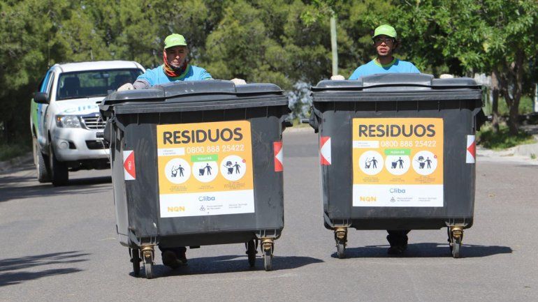 Operarios distribuyendo nuevos contenedores plásticos.