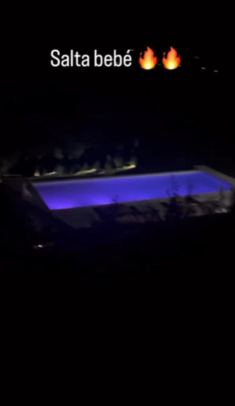 Una vista nocturna de la pileta iluminada.