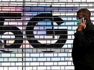 FOTO DE ARCHIVO: Un hombre con mascarilla pasa por delante de un anuncio de 5G mientras en Londres, Reino Unido, 14 de abril de 2020. REUTERS/John Sibley