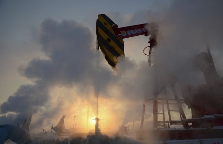 FOTO DE ARCHIVO: Un balancín petrolero es rodeado de vapor durante la puesta de sol en un campo petrolífero de PetroChina en Karamay