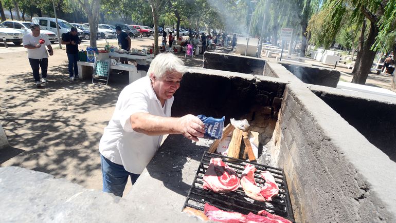 Argentino sala la carne con paciencia. Llegó al balneario con toda su familia.
