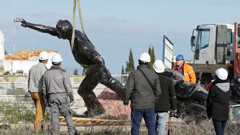 Los operarios sacando una estatua de un dirigente franquista.
