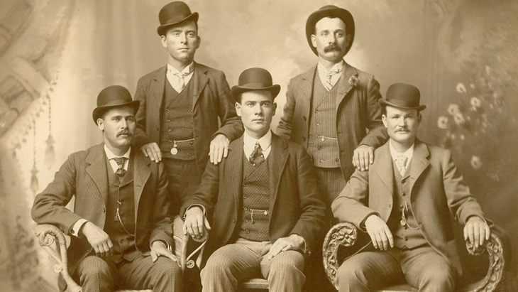 La banda de asaltantes Wild Bunch, con Sundance Kid sentado a la izquierda y Butch Cassidy sentado a la derecha de la imagen. La banda de asaltantes Wild Bunch, con Sundance Kid sentado a la izquierda y Butch Cassidy sentado a la derecha de la imagen.