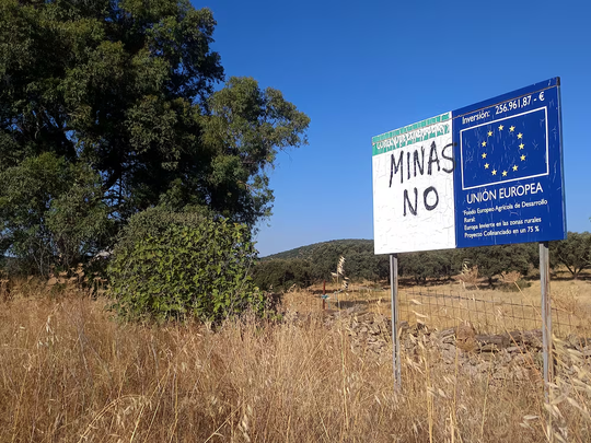 Pintada contra las minas en un cartel de inversiones europeas para el desarrollo rural, en Alconchel (Badajoz). Foto: Luis Velasco, El País