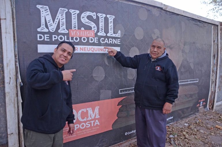 Federico y César junto al afiche publicitario de 44 Resto Bar, que se encuentra sobre la calle Casimiro Gómez.  El aviso que describe el  descomunal sándwich de 60cm. también se encuentra en diferentes puntos de la ciudad.