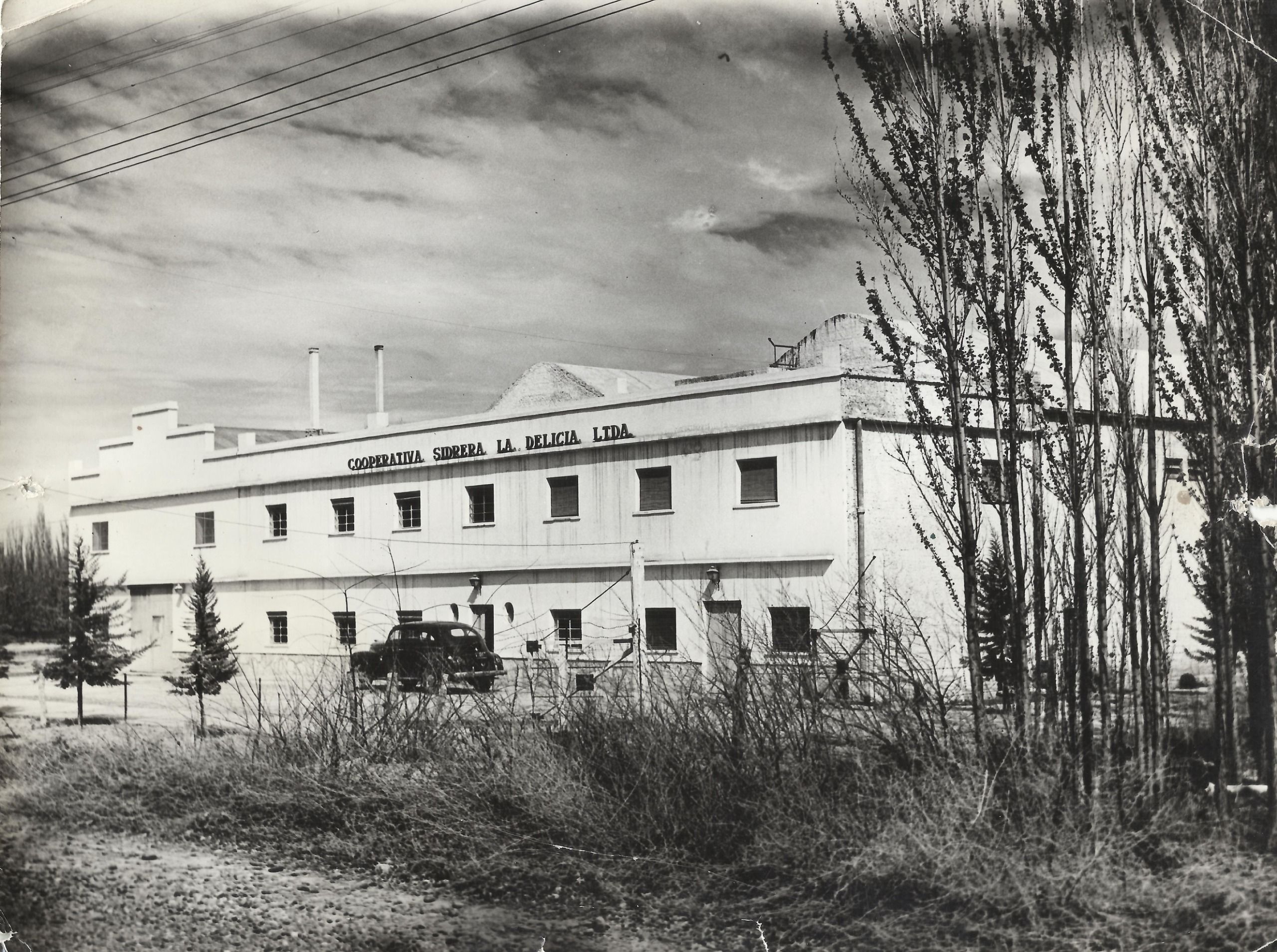 Cooperativa Sidrera La Delicia Ltda, el coche es un Ford modelo 1938 o 1940, sin datos del año - Archivo Municipalidad Cipolletti (Gentileza Fundacion Cabus Trenes)