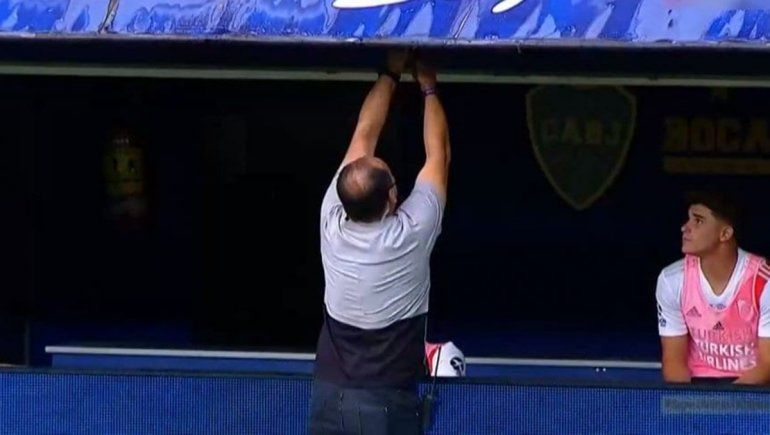 El asistente de Gallardo quitándo el micrófono que colocó Boca.