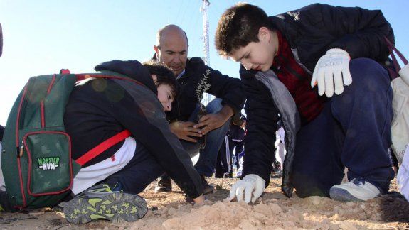 Dos alumnos, junto a Marcelo Bermúdez, en la barda.