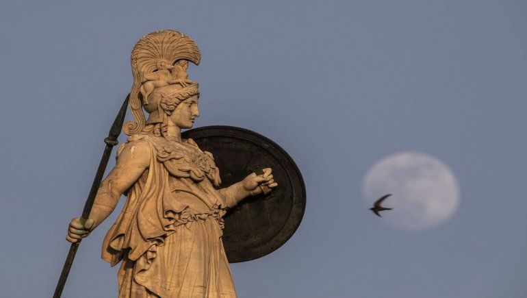 La luna detrás de la estatua de la antigua diosa griega de la sabiduría, Atenea, en lo alto del edificio de la Academia de AtenasPetros Giannakouris - AP