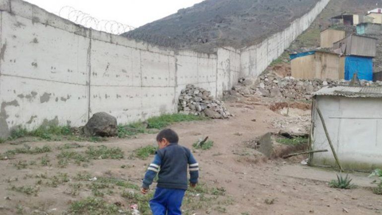Un niño juega junto al muro en el lado pobre del cerro de San Francisco
