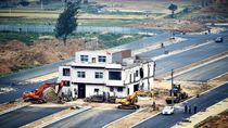 Una casa clavo de tres plantas resiste en mitad de una carretera de Luoyang.