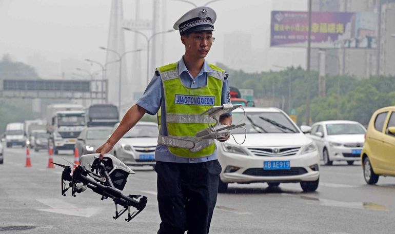 Un policía de tránsito lleva un drone para controlar infractores en Chengdu. Un policía de tránsito lleva un drone para controlar infractores en Chengdu.