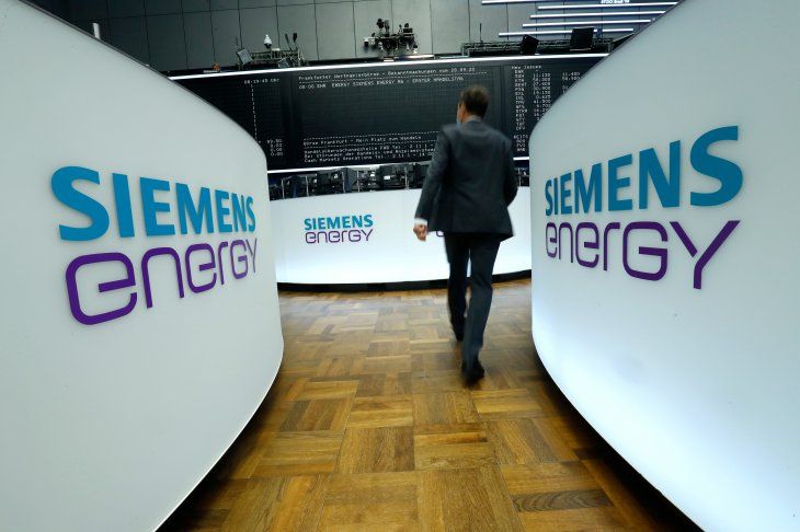 FOTO DE ARCHIVO: Un inversor camina entre los logotipos de Siemens Energy durante su estreno bursátil en el interior del edificio de la Bolsa de Fráncfort, Alemania, el 28 de septiembre de 2020.