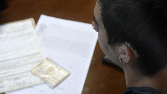 El muchacho vino a la entrevista con un audífono prestado. En la mesa, la denuncia y el carnet de discapacidad.