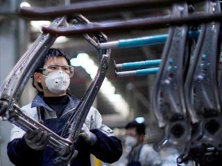 Un empleado con una mascarilla trabaja en una cadena de montaje de asientos de coche en la fábrica Yanfeng Adient de Shanghái, China. REUTERS/Aly Song