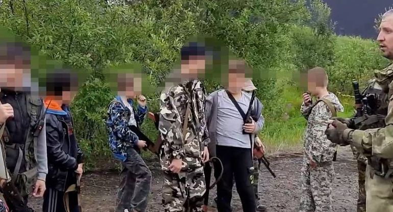 Niños rusos practicando con armas, bajo la guía de miliares. Niños rusos practicando con armas, bajo la guía de miliares.