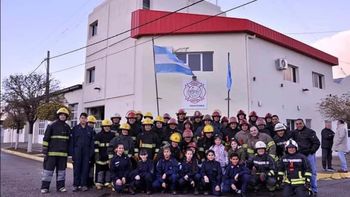 El cuerpo de Bomberos Voluntarios frente al cuartel que, desde este miércoles, hace sonar la sirena todos los días en un singular reclamo.