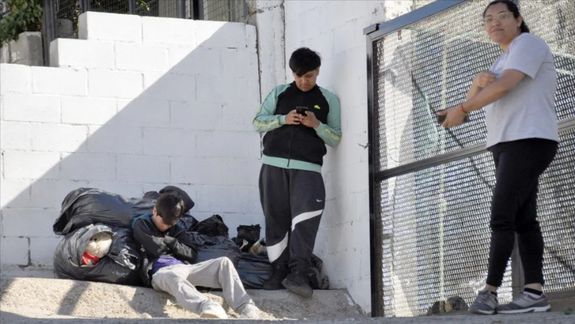 Los hijos de la docente desalojada y una allegada, en el frente de su casa de Comodoro Rivadavia, a la que no los dejan entrar desde el miércoles.&nbsp;&nbsp;