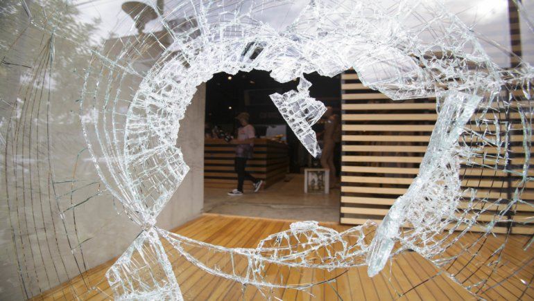 El delincuente rompió el blindex del comercio de un piedrazo para cometer el robo.