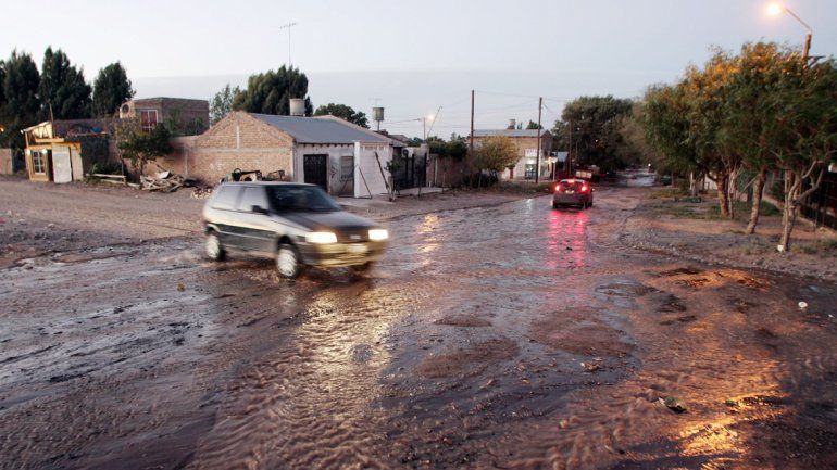 El agua que viene de la cisterna corre por las calles del barrio.