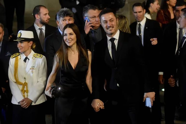 Cristina Pérez lució un vestido de cocktail cruzado y Luis Petri con traje oscuro, camisa blanca y corbata oscura. Foto: Google. Cristina Pérez lució un vestido de cocktail cruzado y Luis Petri con traje oscuro, camisa blanca y corbata oscura. Foto: Google.