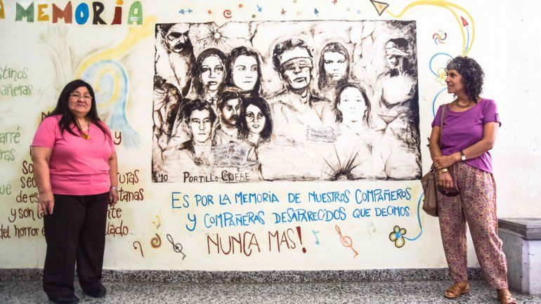 Gladis Sepúlveda y Elida Sifuentes junto al mural que recuerda a sus compañeras estudiantes desaparecidas de la carrera de Servicio Social de la UNCo.&nbsp;