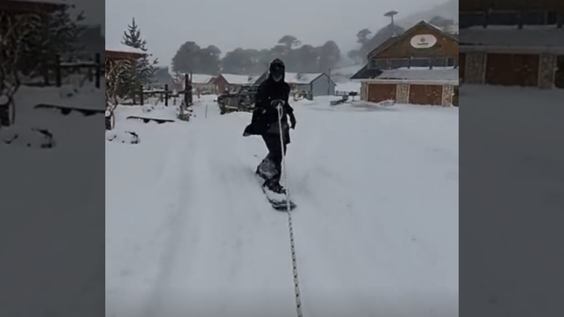 Un guía de Caviahue montó su snowboard en las calles de la localidad tras el temporal de nieve.