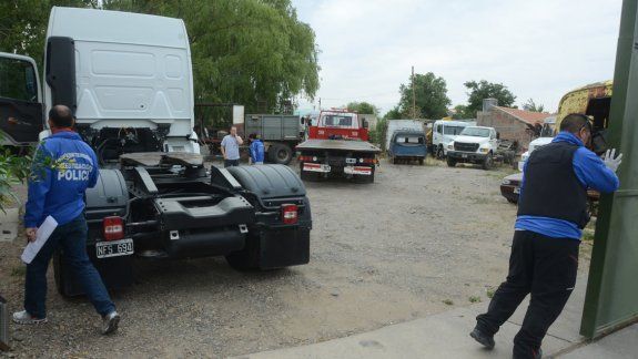 Mauro y su padre, Fernando Machado, en la audiencia de octubre pasado. Personal de Delitos Económicos durante los allanamientos a los predios de la familia donde guardan los camiones.