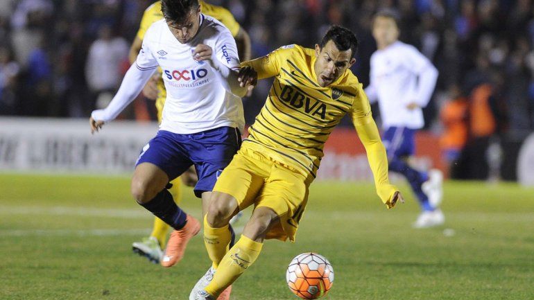 Tevez es seguido de cerca por el defensor uruguayo.