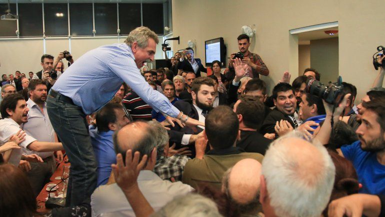 El diputado Agustín Rossi se trepó a las mesas y trató de separar.