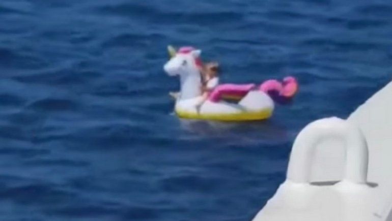 Una nena, a la deriva en el mar con su unicornio flotante
