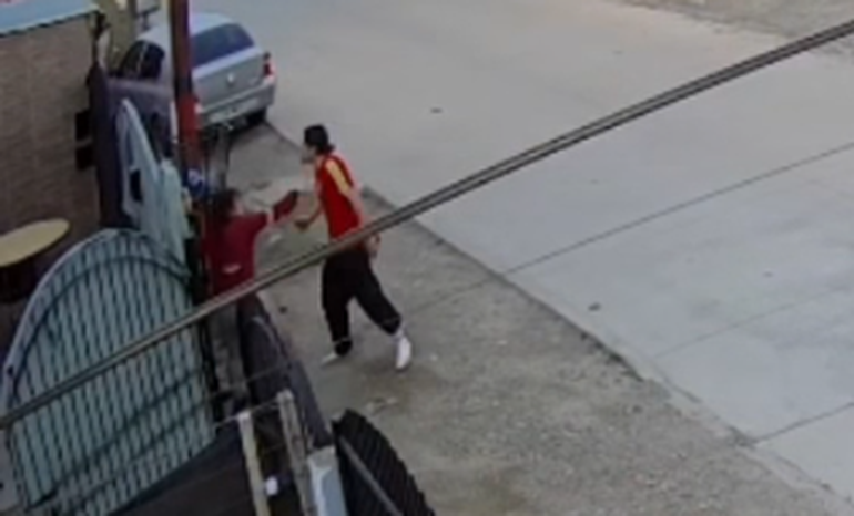 El momento en que el agresor acorrala a la víctima contra una reja. El momento en que el agresor acorrala a la víctima contra una reja. 