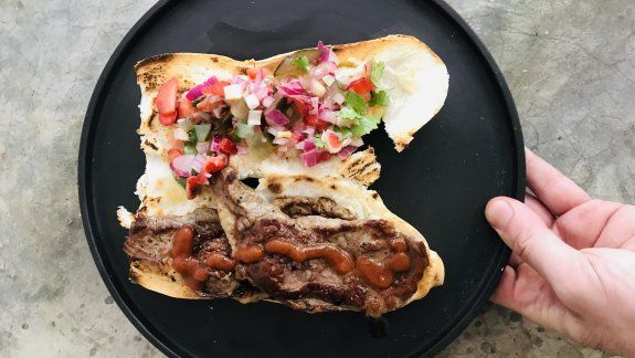 Bife de chorizo con criolla de frutillas y pepinillos