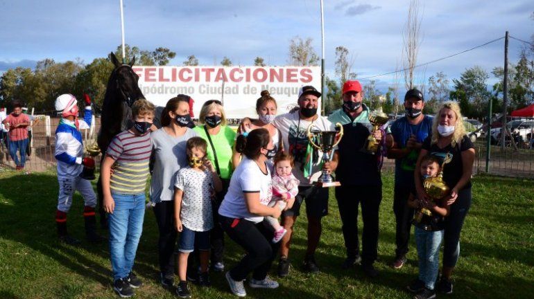 Francesca con el trofeo en sus manos junto a sus padres, el cuidador, el jockey, la familia de la Pichi Perla y el entorno del campeón.