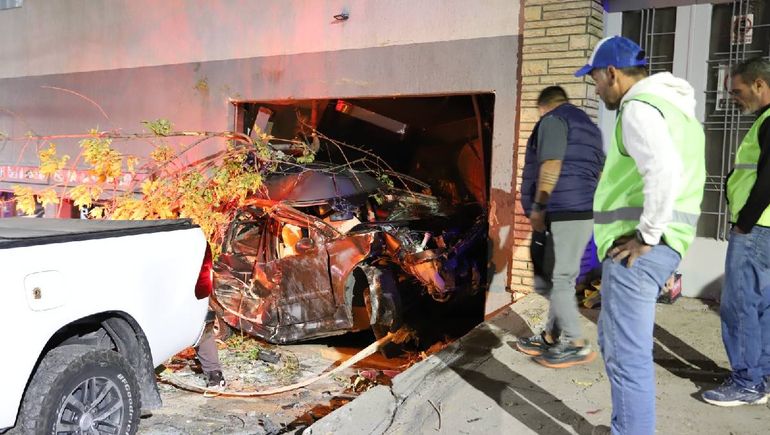 Personal municipal y la Policía sacaba ayer un vehículo incrustado en un garaje de la calle Salta.