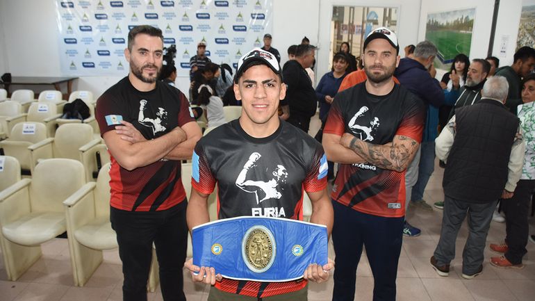 Axel Isla con el cinturón de campeón y el acompañamiento de su equipo.&nbsp;