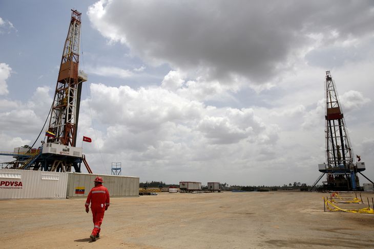 FOTO DE ARCHIVO: Un trabajador de un campo petrolero camina junto a las plataformas de perforación en un pozo petrolero operado por la estatal venezolana PDVSA, en la rica franja petrolera del Orinoco