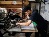 Un trabajador de una empresa de impresión y comercialización, cuyos empleados ya trabajan 40 horas a la semana, es fotografiado mientras el congreso vota y aprueba un proyecto de ley que reduce el