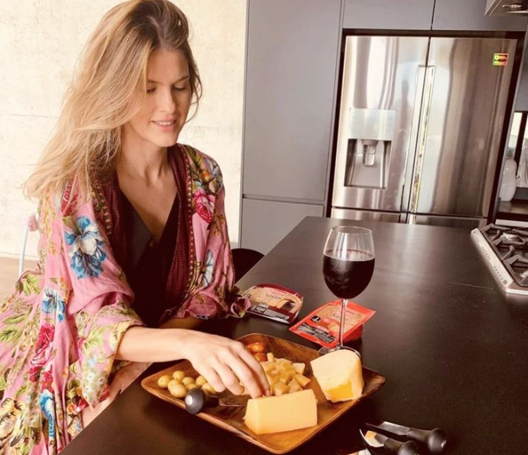 Una amplia isla en madera oscura domina el centro de la cocina.